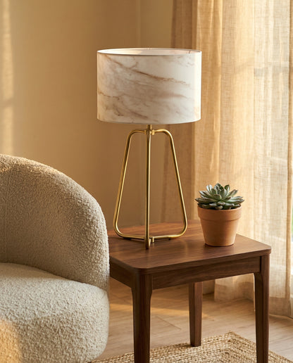 Vesper Table Lamp brass tripod base with warm ambient glow on surface